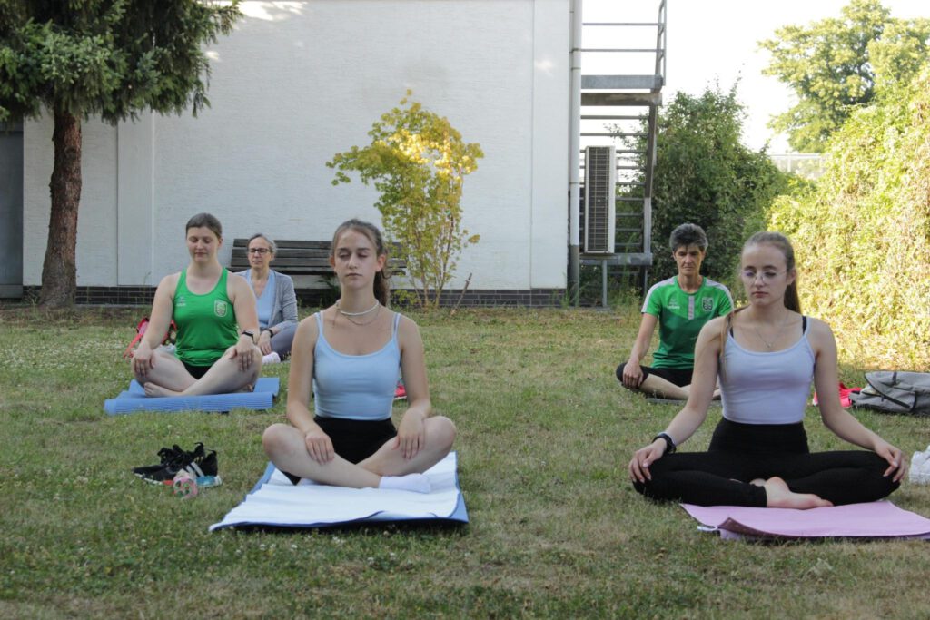 Menschen machen Yoga im TVE Garten